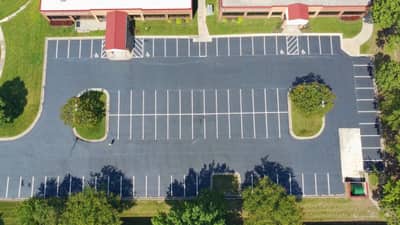Aerial view of a newly paved asphalt parking lot with landscaped islands at a medical office building