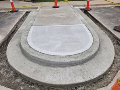 New rounded concrete curb island, coned off while it cures