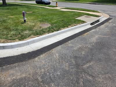 New concrete curb and gutter along a lawn edge at a commercial property